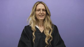Blonde woman in judge uniform gestures enthusiastically against isolated purple background, conveying authority and confidence with expressive hands and a joyful smile. - Powered by Shutterstock - Get 15% off with code: PIKWIZARD15