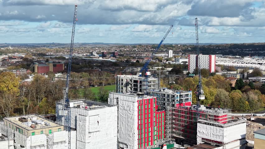 A construction site dominated by cranes , emphasizing growth and the evolution of the urban landscape in modern cities in London UK