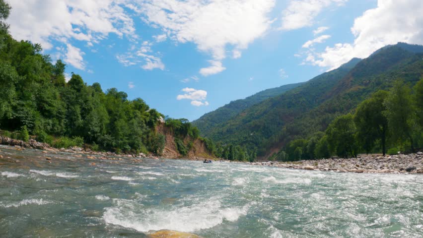 4K shot of river rafting in Manali, Himachal Pradesh, India. View from the Rafting boat and splashing river water of Beas river in Manali. Adventure sports and holidays activity concept