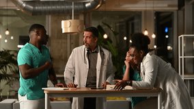 Multiethnic group of doctors and nurses discussing patient cases during a late night hospital meeting. Medical staff collaborating and brainstorming - Powered by Shutterstock - Get 15% off with code: PIKWIZARD15