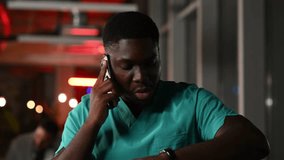 Anxious african american male doctor in scrubs receiving bad news on a phone call. Stressed surgeon rubbing his eyes, feeling tired - Powered by Shutterstock - Get 15% off with code: PIKWIZARD15