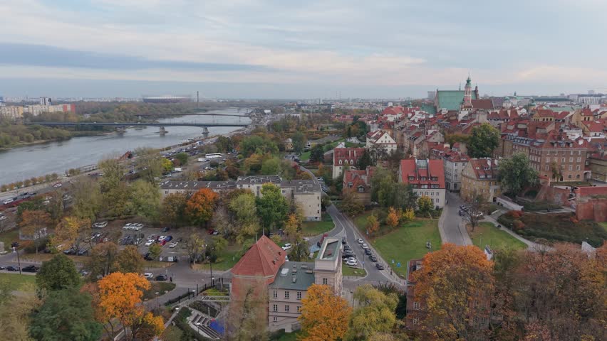 Aerial drone flyby near the historic Dominican Order Church in Warsaw’s Old Town, Poland, showing its elegant architecture surrounded by narrow streets and colorful rooftops.