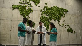 Multiracial group of doctors and nurses collaborating on a case. Medical professionals discussing global health in front of a world map - Powered by Shutterstock - Get 15% off with code: PIKWIZARD15