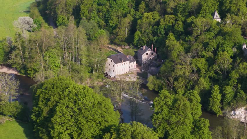 lesse river below small homes old historical site green cover fields trees to from left right aerial panning shot dinant belgium riverside