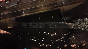 Nighttime view through a geometric glass wall showing a lit interior lobby with contemporary decor, reflective flooring, and structured lighting in a commercial or office building. - Powered by Shutterstock - Get 15% off with code: PIKWIZARD15