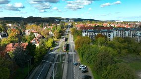 Aerial view of tram and cars moving through residential district in Gdańsk, Poland, surrounded by autumn trees and cityscape. - Powered by Shutterstock - Get 15% off with code: PIKWIZARD15