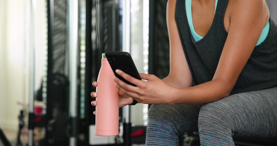 Focused woman exercising at gym, wearing athletic tank top, looking determined. Fitness, workout, exercise, training, athlete, motivation