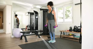 Young woman doing lunges with dumbbells in home gym, focused on exercise. fitness, workout, strength, training, wellness - Powered by Shutterstock - Get 15% off with code: PIKWIZARD15