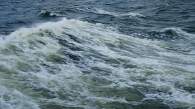 Choppy ocean waves under stormy sky, dark navy water roils as brisk wind whips white foam and spray, distant boat wake hints passage, heavy clouds hang low - Powered by Shutterstock - Get 15% off with code: PIKWIZARD15