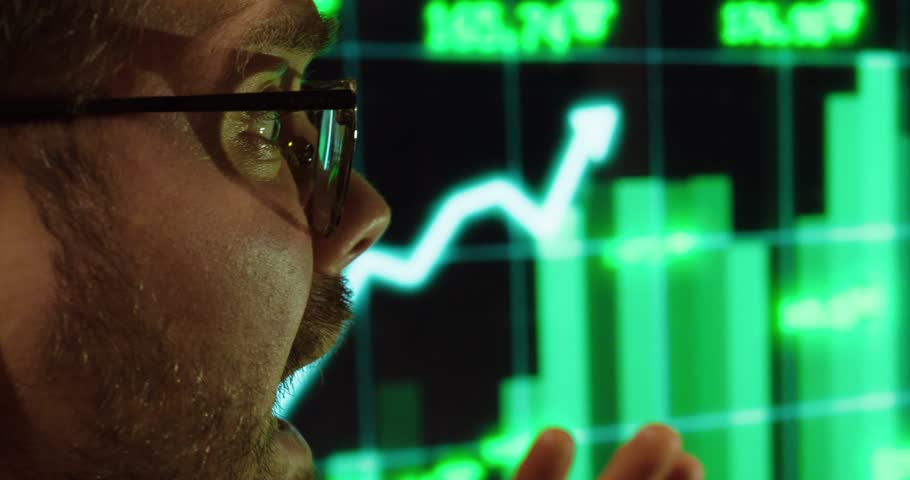 A man reacts emotionally to the rapidly rising stock market data. Concept of success, excitement, and financial gains in trading.