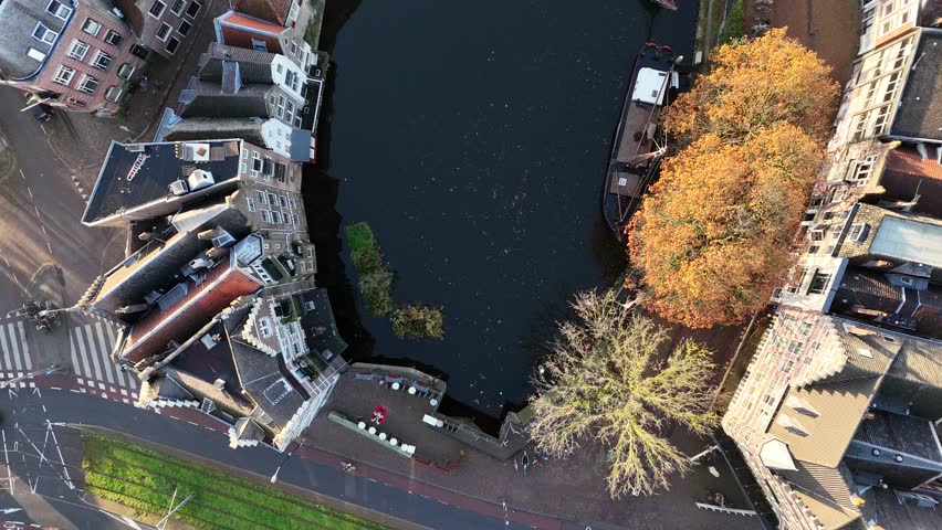 Aerial drone video of Rotterdam, Netherlands, featuring a picturesque canal, unique architecture, and vibrant autumn trees along the water—capturing the charm and beauty of this dynamic European city.