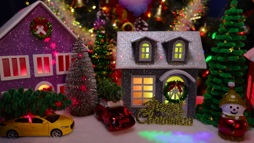 Against the backdrop of a large Christmas tree and a Christmas wreath in a Christmas town, in front of the houses, cars and letters