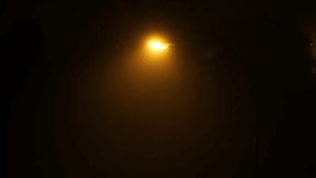 Single street lamp illuminating a thick, slow moving autumn fog at night. Elevated point of view, dark moody scene, real time footage, no people - Powered by Shutterstock - Get 15% off with code: PIKWIZARD15