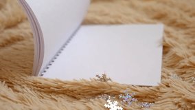 Blank notepad, turning empty pages, place for text. New year's goals notebook. Christmas decorations and warm beige plaid. Empty space for text. New year celebration. - Powered by Shutterstock - Get 15% off with code: PIKWIZARD15
