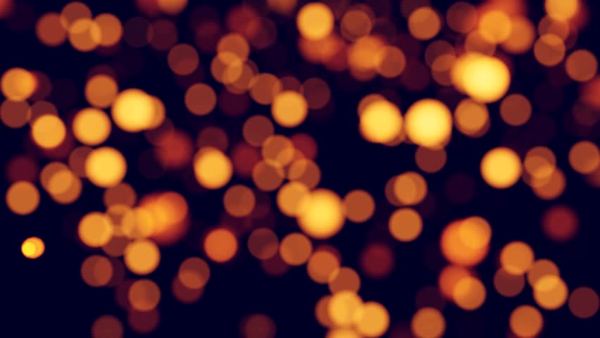 Bright golden bokeh lights glowing on a black background perfect for Christmas and holiday design. Seamless loop.