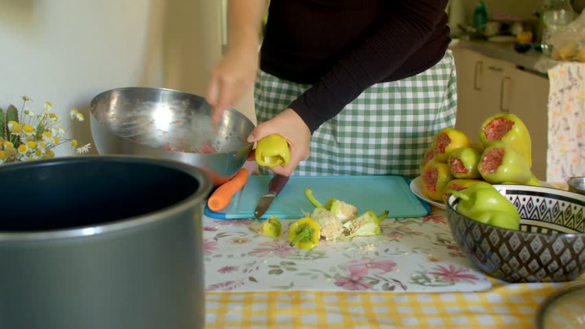preparing savory stuffed fruit, home scene of stuffing quince with meat, focused home cooking of savory stuffed quince in progress, detailed scene of preparing and stuffing quince with meat at home