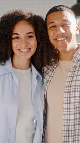 Slow motion of a young African American happy loving couple rejoicing in moving to a new dream apartment, hugging each other, expressing happiness and joy, showing the keys to the new home to camera