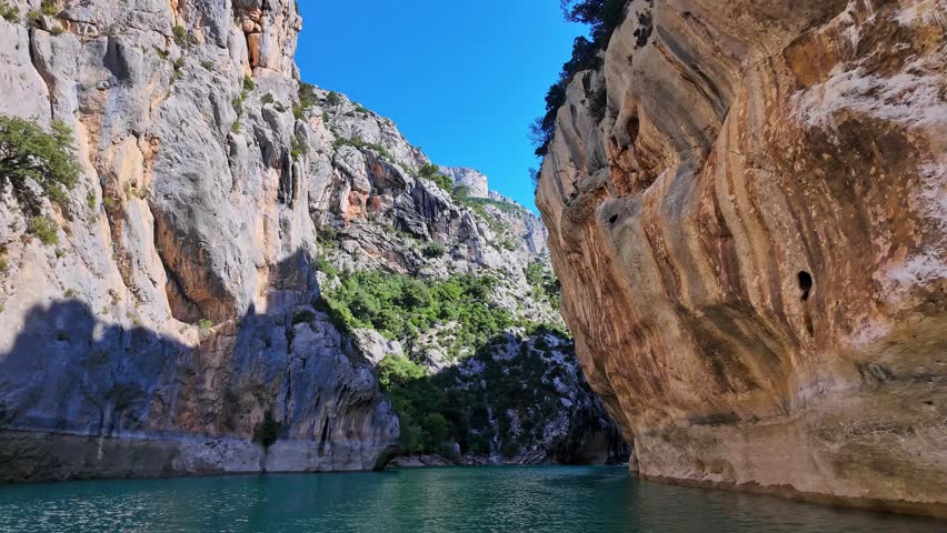 Boat trip on turquoise water of mountain canyon, Verdon Gorge in french Alps, Provence France. Near Aiguines. Canyon is about 25 kilometres long and up to 700 metres deep.