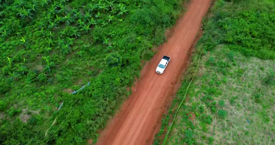 Aerial view of a moving truck on tropical forest road