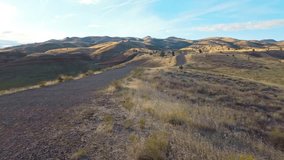 Panoramic view of the Painted Hills, showcasing their vibrant layers of red, gold, and black as seen from the elevated Carroll Rim Trail viewpoint at the John Day Fossil Beds National Monument - Powered by Shutterstock - Get 15% off with code: PIKWIZARD15