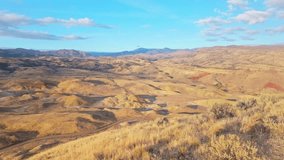 Panoramic view of the Painted Hills, showcasing their vibrant layers of red, gold, and black as seen from the elevated Carroll Rim Trail viewpoint at the John Day Fossil Beds National Monument - Powered by Shutterstock - Get 15% off with code: PIKWIZARD15