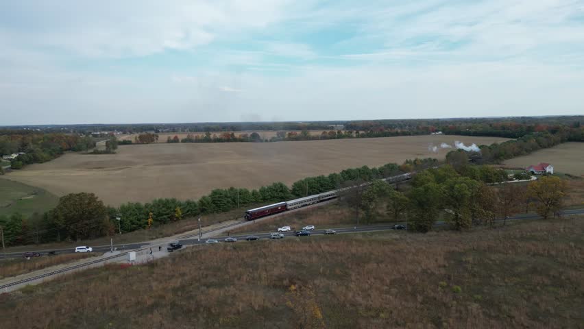 Nickel Plate Road 765 Steam engine running from Pleasant Lake Indiana through the country side  in fall colors drone aerial