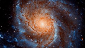 Hubble telescope view of a vibrant spiral galaxy rotating with orange core and blue stellar arms - Powered by Shutterstock - Get 15% off with code: PIKWIZARD15