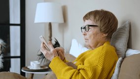 Side view of a senior woman with glasses using her mobile phone while resting in bed at home, browsing social media or online shopping, staying connected with family and friends - Powered by Shutterstock - Get 15% off with code: PIKWIZARD15