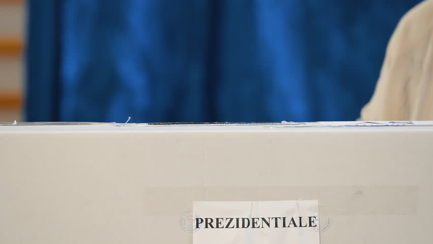 Voter casting ballot into box, close-up election scene