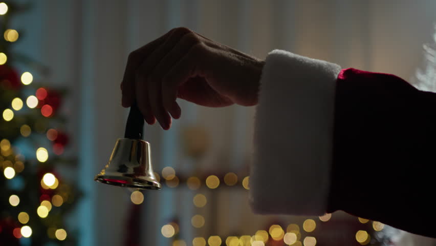 Santa ringing a small bell with his hand 