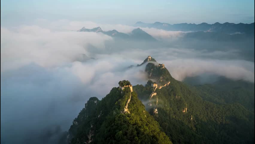 Stunning aerial view of Great Wall of China shrouded in morning mist with lush mountains in background showcasing ancient history