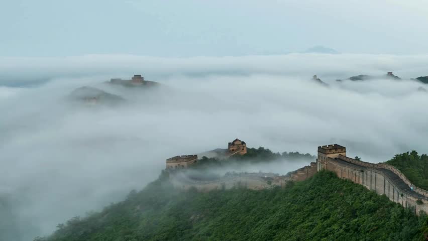 Majestic views of Great Wall of China shrouded in morning mist with lush greenery surrounding ancient fortifications