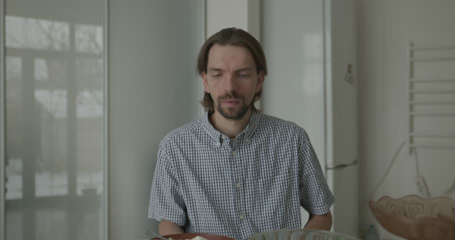 Man is Eating Breakfast in Kitchen. 4K 10-bit