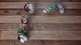 Small Christmas ornaments on rustic plank table. Man's hand places cup of eggnog with ground cinnamon in it on the table and then stirs the drink with a cinnamon stick. - Powered by Shutterstock - Get 15% off with code: PIKWIZARD15