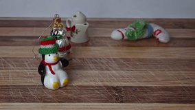 Small Christmas ornaments on rustic plank table. Man's hand places cup of eggnog with ground cinnamon in it on the table and then drops a cinnamon stick in the drink. - Powered by Shutterstock - Get 15% off with code: PIKWIZARD15