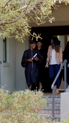 Walking diverse teenage graduates with mentor descending brick steps on campus, holding diplomas. Commencement, achievement, celebration, camaraderie, academic, education, outdoor