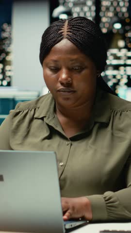 Vertical Video Triumphant associate enjoys a quiet moment of downtime in a corporate office, reclining in her chair with a comfortable and laid back posture. Resting after tasks, radiates empowerment