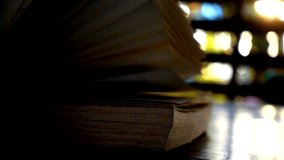 A close-up of a book resting on a wooden table as someone gently turns its pages. The warm, soft light creates a tranquil atmosphere in a serene library setting. - Powered by Shutterstock - Get 15% off with code: PIKWIZARD15