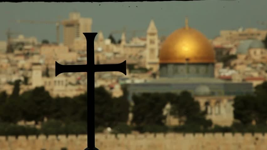 Side view of the Dome of the Rock in jerusalem in background with cross christian temple on focus