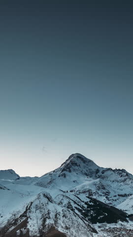 Stepantsminda, Georgia. Winter Night Starry Sky With Glowing Stars Over Peak Of Mount Kazbek Covered With Snow. Beautiful Night Georgian Winter Landscape