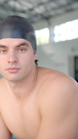 Vertical video: Male swimmer in black swim cap, breathing and tilting head for training at poolside. Athletic, concentration, mindfulness, fitness, aquatic, modern, vertical video