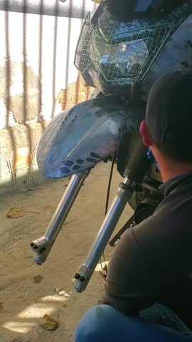 Authentic hands-on moment of a traveler or mechanic setting up his customized off-road vehicle for a rugged journey.