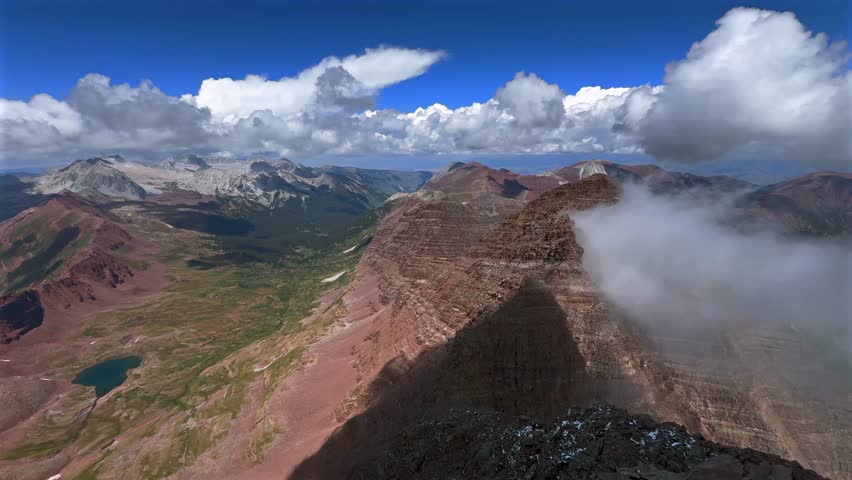 Capitol Peak Mount Snowmass Colorado summer panoramic view from North Maroon Peak Aspen Snowmmass Maroon Bells Wilderness fog snow sunny fourteener Elk Range Rocky Mountains rugged terrain pan left