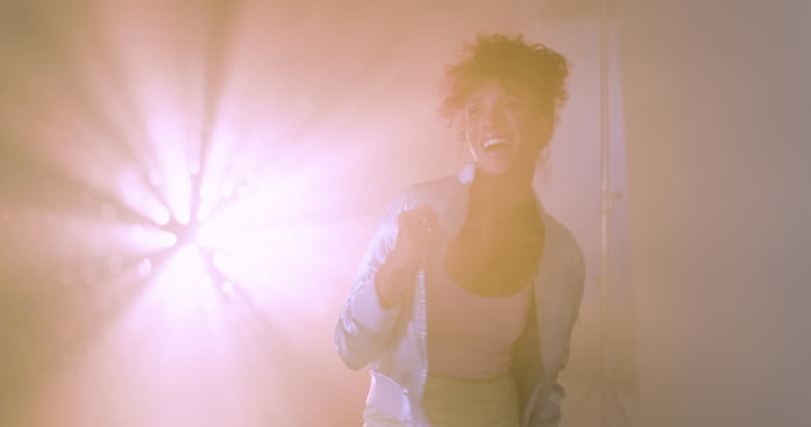 Young woman in grunge style posing confidently in hazy studio lighting. Fashion, alternative, urban, edgy, portrait, trendy