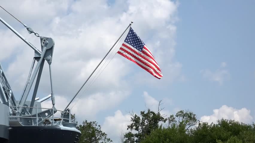 Flag waving on a military navy vessel. Highlights patriotism, naval power, and disciplined maritime operations in a powerful, proud display.
