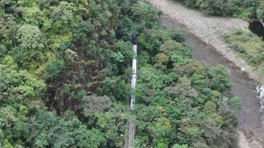 Following the railway line running alongside the Urubamba River bank through lush jungle as it travels toward Aguas Calientes (Machu Picchu Pueblo) station