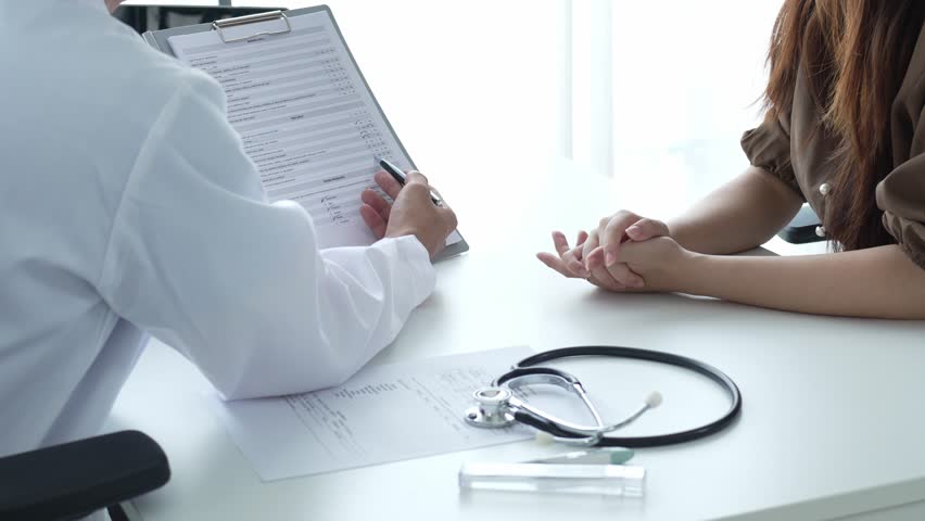 Doctor Holding Medicine Bottle Explaining Dosage to Patient