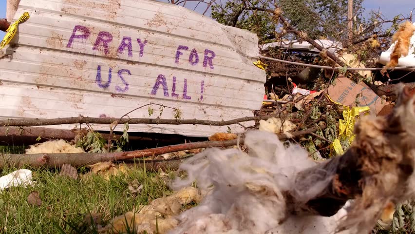 Debris from a tornado with “Pray For Us All” written on a piece of wood, capturing natural disaster aftermath and human emotion in 4K.
