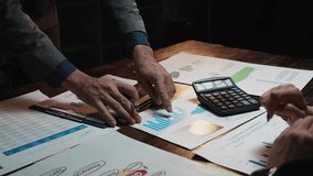 Business colleagues analyzing financial documents, graphs, and charts during a late night meeting - Powered by Shutterstock - Get 15% off with code: PIKWIZARD15