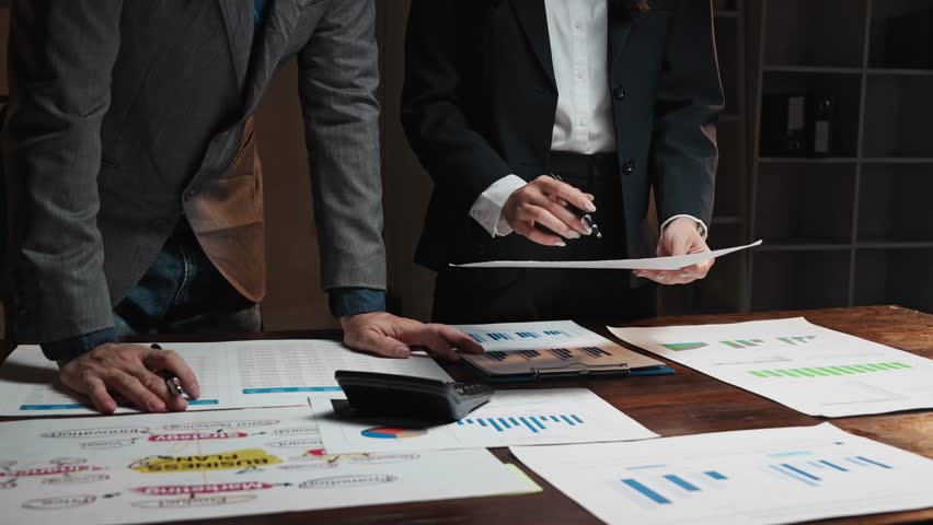 Business colleagues discussing and analyzing financial market data on a meeting table in the office